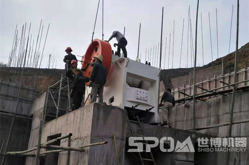 石場大型顎式破碎機安裝現(xiàn)場，需要四五人合力